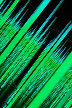 Green LED light poles at angle in abstract Foto stock