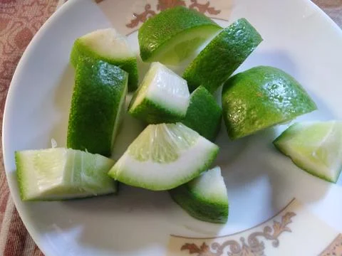 Green Lemon slice on ceramic plate. Healthy lemon for dietitian Stock Photos