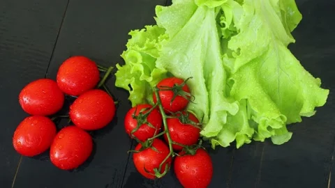 Green lettuce and small red tomatoes on a branch Stock Footage 236542296