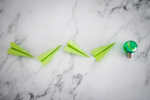Green light bulb idea next green paper planes metaphor of new ideas and inven Stock Photos