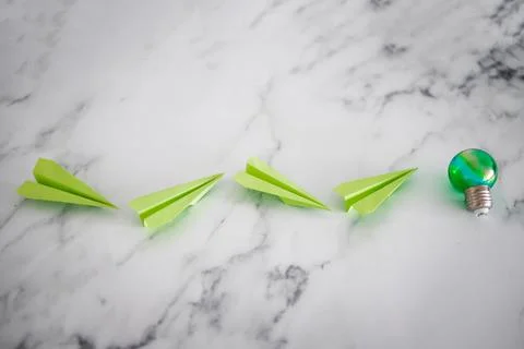 Green light bulb idea next green paper planes metaphor of new ideas and inven Stock Photos