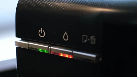 The green light on the printer is on and the red light is flashing, indicating a Stock Footage 313375085