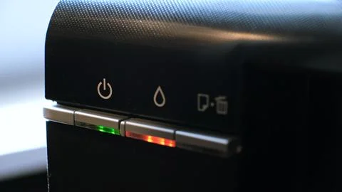 The green light on the printer is on and the red light is flashing, indicating a Stock Photos