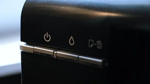 The green light on the printer is flashing, indicating of the device or ready to Stock Photos