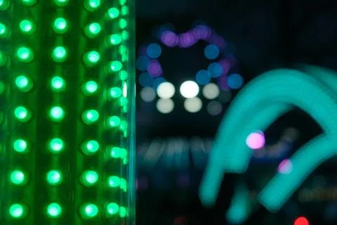 A green lighted cactus is surrounded by a blurry background Stock Photos