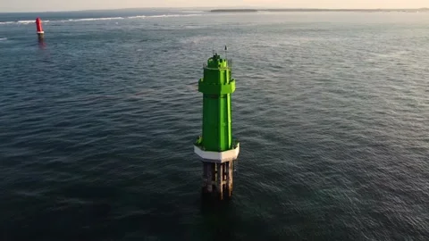 Green lighthouse in the ocean on sunset Stock Footage 156335563