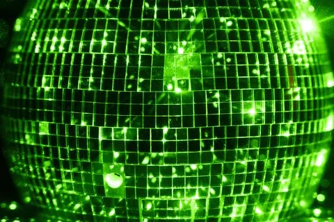 Green lights reflected in disco ball on black backdrop Stock Photos