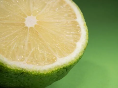 Green lime on a colored background. Close-up. Half a citrus fruit. Stock Photos