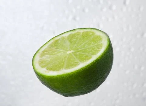 Green lime fruit on dewy background Stock Photos