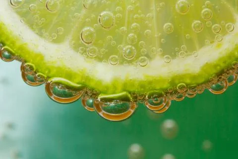 Green lime with water splash Stock Photos