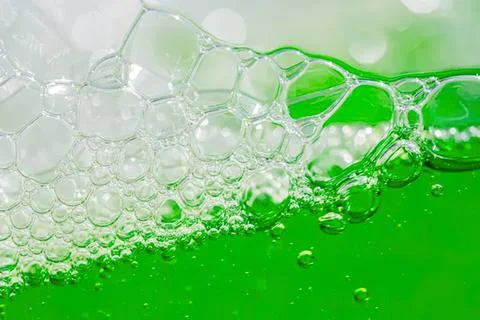 Green liquid with bubbles in a close-up shot Stock Photos