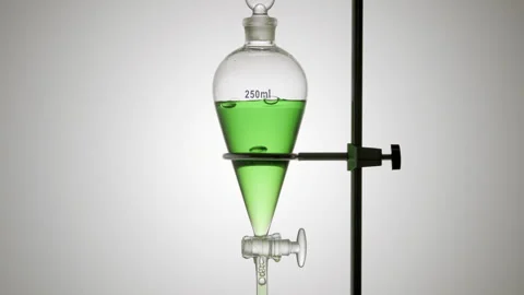 Green liquid drips from separatory funnel bubbles rise grey Stock Footage 341838028