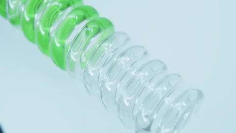 Green liquid flows down a glass spiral pipe. Stock Footage 248319553