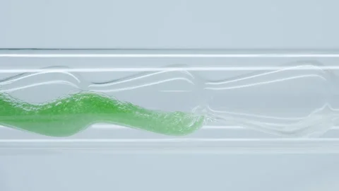 Green liquid gracefully flows through the glass tube.  Stock Footage 270163501