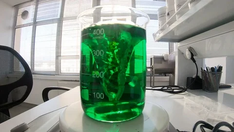 Green liquid mixed inside a flask at a supplement laboratory Stock Footage 101218033