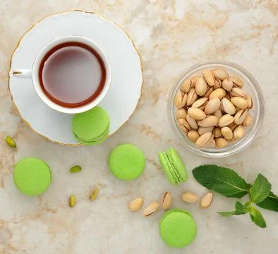Green macaron with a cup of tea Stock Photos