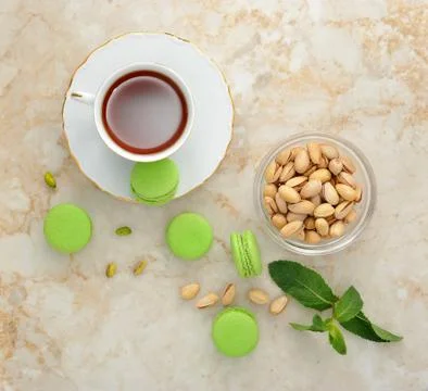 Green macaron with a cup of tea Stock Photos
