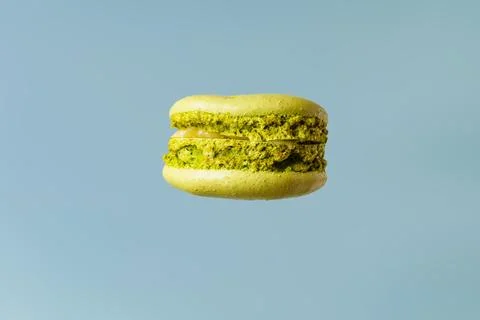 Green macaroons on a blue background side view isolate Stock Photos