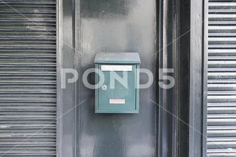 Green mailbox on a wall, detail of a mailbox post cartes, correspondence Stock Photos