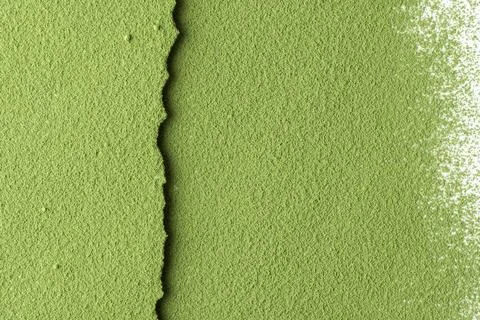 Green matcha powder forms a textured split background with a torn edge, ideal Stock Photos