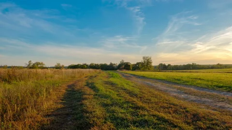Green meadow under sunset sky with clouds, time lapse video Stock Footage 95040573