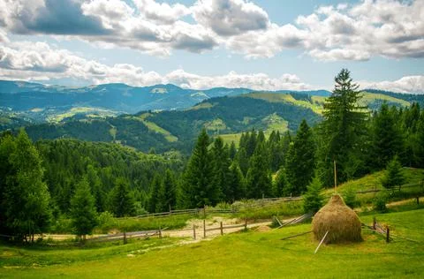 Green meadows in the Carpathian Mountains with a haystack in the foreground Stock Photos