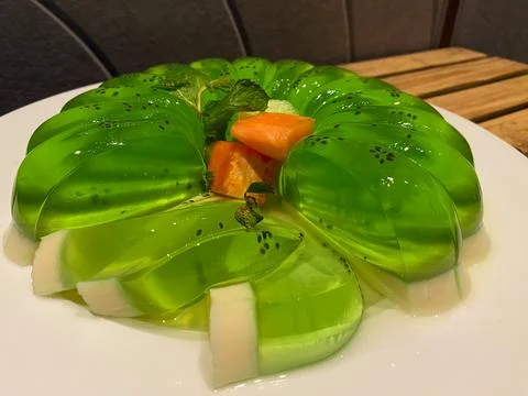 Green melon pudding served on white plate Stock Photos