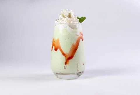 Green milkshake on a light background. Stock Photos
