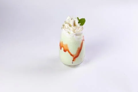 Green milkshake on a light background. Stock Photos