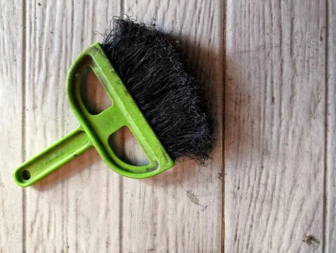 Green mini broom on the floor Stock Photos