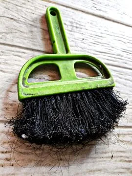 Green mini broom on patterned ceramic floor tiles Stock Photos