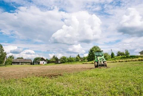 A green mini skid steer loader clear the construction site. Land work by the Foto stock