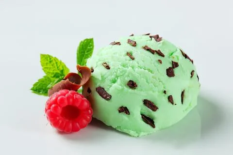 Green mint ice cream with chocolate chips and raspberry Stock Photos
