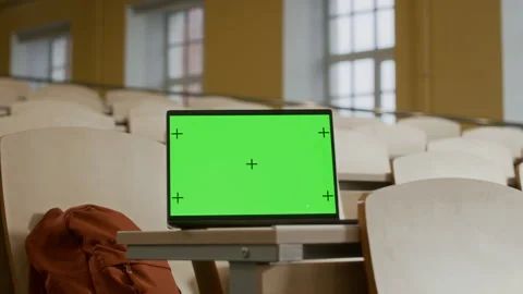 Green Mockup Screen of Laptop Placed on Desk in University Lecture Hall Stock Footage 306678682