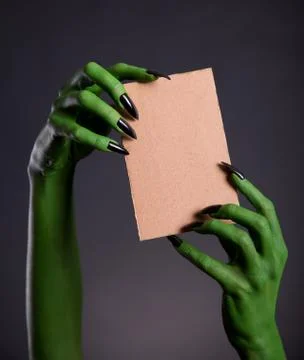 Green monster hands holding empty piece of cardboard Fotos de archivo