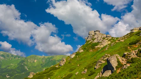 Green mount slope under cumulus clouds time lapse scene Stock Footage 240746765