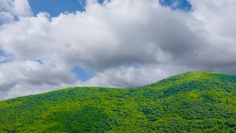 Green mountain chain under a dense cloudy sky time lapse scene Video stock 301085471