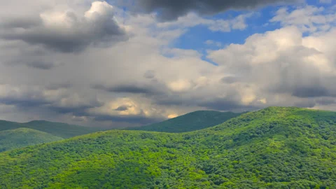 Green mountain chain under dense cloudy sky Vídeos de archivo 314311132