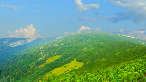 Green mountain chains under a blue cloudy sky Stock Footage 301082674