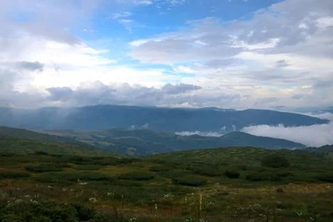 Green mountain with floating cloud and blue sky Stock Photos