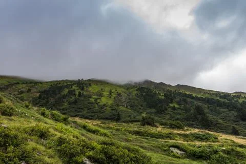 Green mountain landscape with rainclouds while hiking Stock Photos