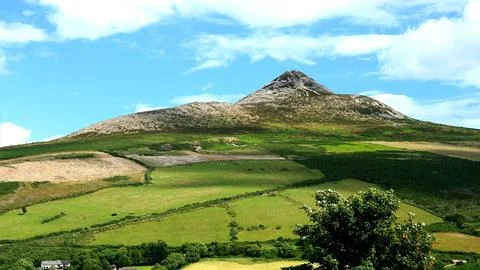 Green Mountain Landscape with Rolling Fields and Blue Sky Stock Photos