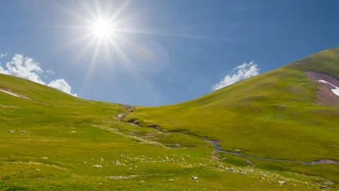 Green mountain pass under sparkle sun time lapse scene Stock Footage 250154284