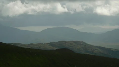 Green mountain range and the gray, cloud-covered sky Stock Footage 255505074