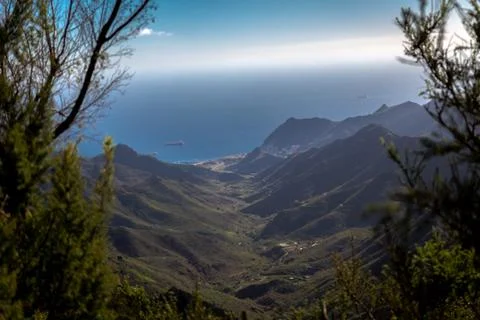 A green mountain range with the ocean in the background Stock Photos