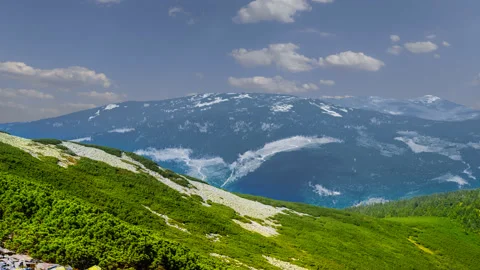 Green mountain ridge under a cloudy sky, natural mountain time lapse scene Stock Footage 147486498