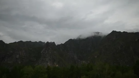 Green mountain slopes covered with thick white clouds in daylight. Stock Footage 315901791