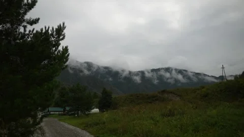 Green mountain slopes covered with thick white clouds in daylight. Stock Footage 315901808