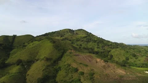 A green mountain with steep slopes covered with forest trees and meadow grass. Stock Footage 193407907
