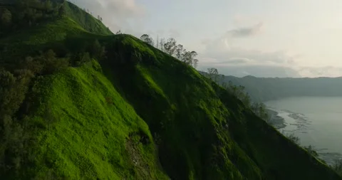 Green mountain with trees under cloudy sky seen from above Stock Footage 266881783